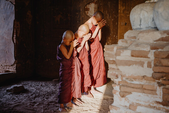 Young monks performing religious gestures in the temple