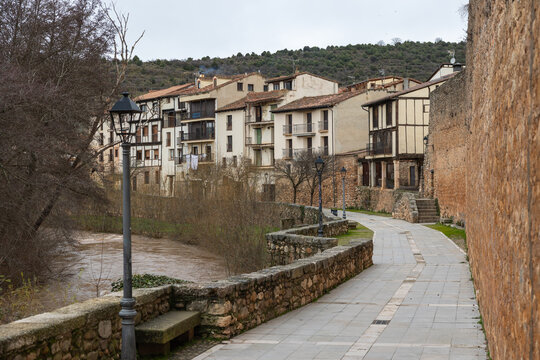 Covarrubias village houses and arlanza river with stone wall