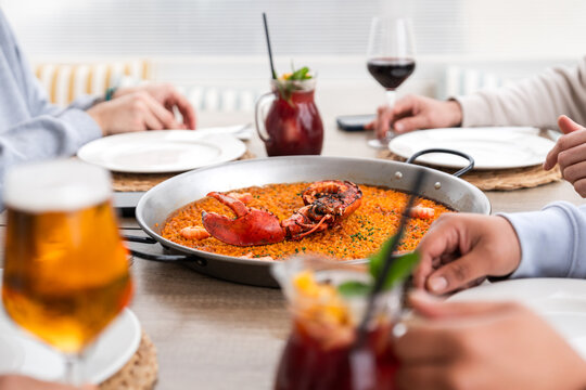 Friends enjoying seafood paella in a restaurant