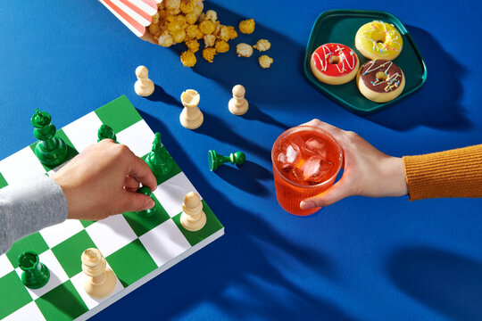 two glasses of whiskey on a chessboard with chess pieces.