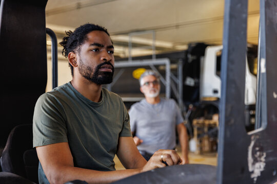 Technician operating forklift at automobile industry