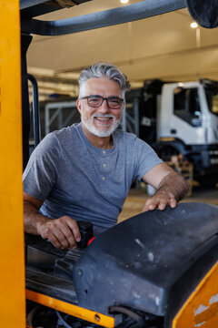 Smiling technician driving forklift in industry