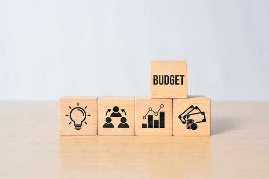 Wooden blocks with budget text and financial growth icons on desk background. Corporate financial management, cost optimization, business expansion strategy, profit improvement concept.