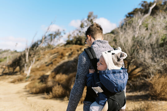 young father hiking in san diego california with son in baby carrier