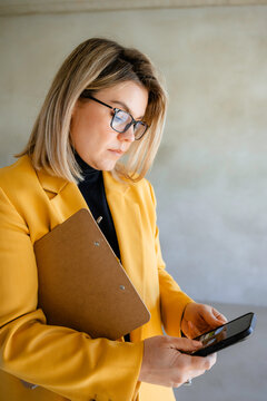 A woman uses a mobile phone at a construction site