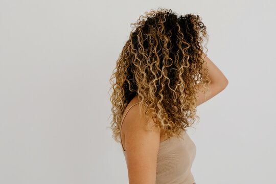 Anonymous slim lady model with curly hairstyle