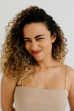Cheerful woman with curly hairstyle making face