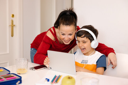 Aunt and nephew enjoying music together while using tablet