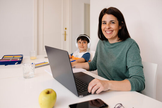 Mother and son using technology in a bright living room