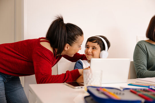 Aunt giving affection to nephew at home during study time