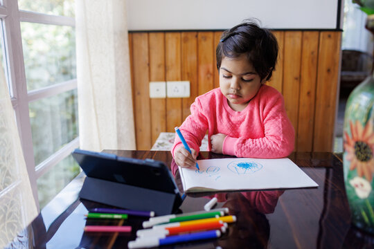 Little girl drawing with sketch pen