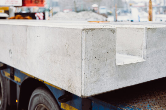 Prefabricated concrete slab transported on a trailer, ready for installation. High-quality precast element showcasing precision and durability in modern construction.