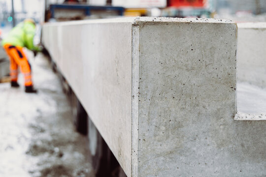 Long prefabricated concrete slab aligned on a construction site with shallow depth of field. Industrial building material prepared for large-scale infrastructure projects.