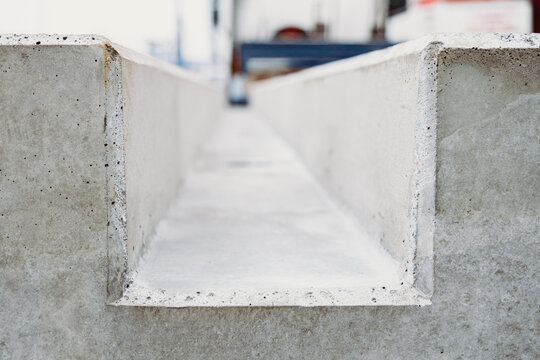 Symmetrical view of prefabricated concrete channel elements forming an industrial pattern. Precision-made precast components used in infrastructure and drainage systems.