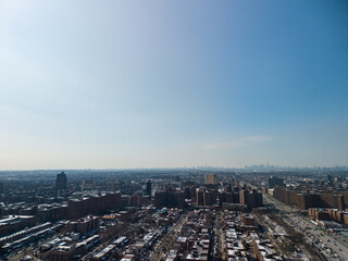Obraz premium Aerial view showing forest hills, queens, with residential buildings and traffic on the long island expressway, extending towards the distant manhattan cityscape under a clear blue sky