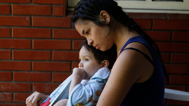 Mother cuddling her baby outdoors