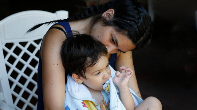 Mother cuddling her baby outdoors