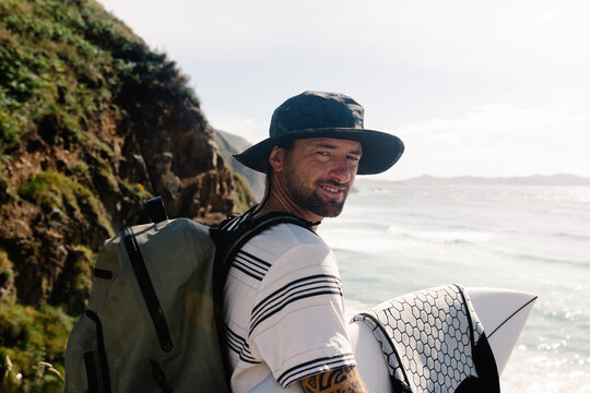 Portrait of happy tourist posing with his surf gear at Campello beach