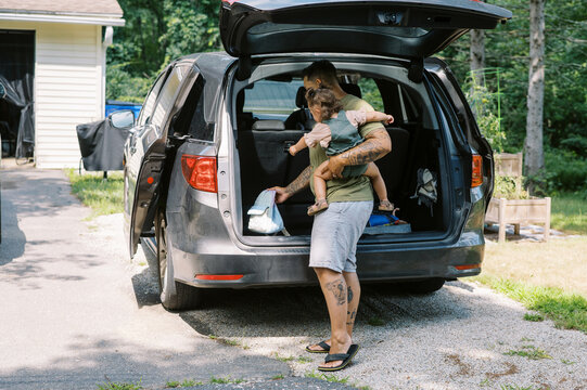 smiling lgbtq mother and daughter getting ready to drive the car