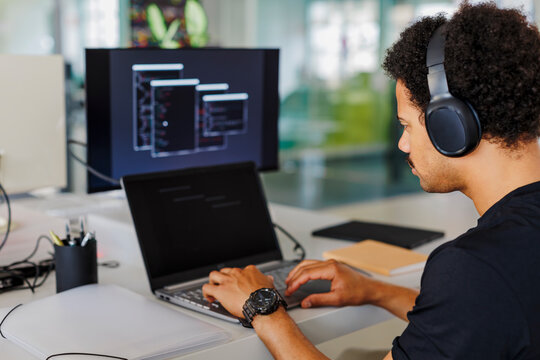 Software developer writing code on laptop working on computer
