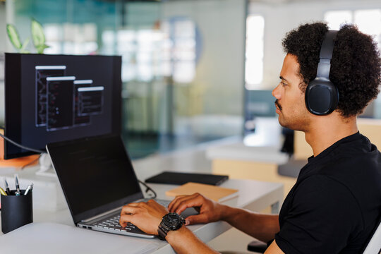Focused young programmer working on code at his desk