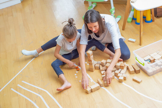 Babysitter plays with a child. Woman and child play. View from above