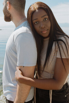 Interracial Couple Embracing Outdoors by the Water