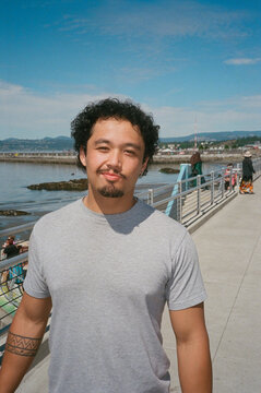 Man Smiling By Waterfront On A Bright Sunny Day