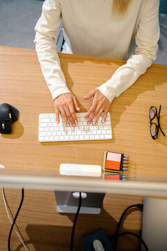 Woman Hands Typing on Keyboard at Desk Top View