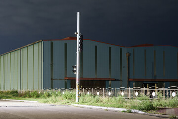 Obraz premium Industrial Warehouse Building Under Dark Stormy Sky