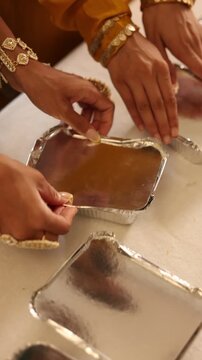 A rich Indian woman packing sweet food for less fortunate people