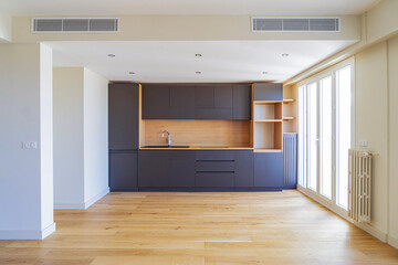 Modern minimalist kitchen interior with wooden floor and natural light