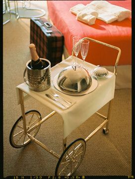 A service trolley with a deluxe bassinet and a bottle of champagne
