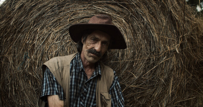 Villager takes a break beside a bale of hay