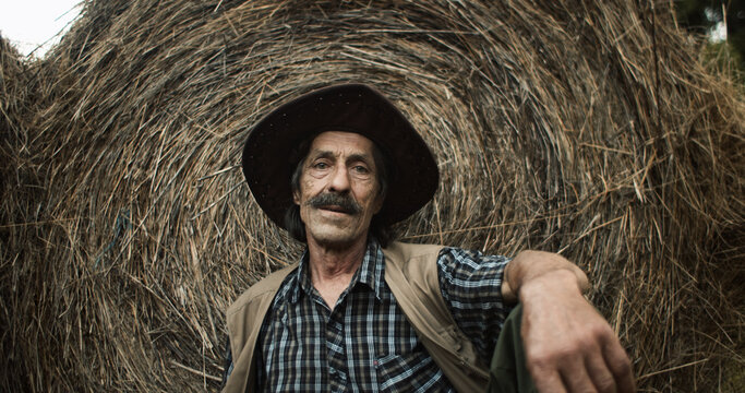 Villager rests next to a hay bale
