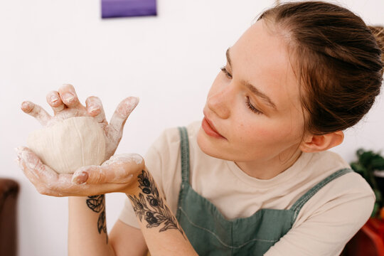 Woman touching rim of clay bowl