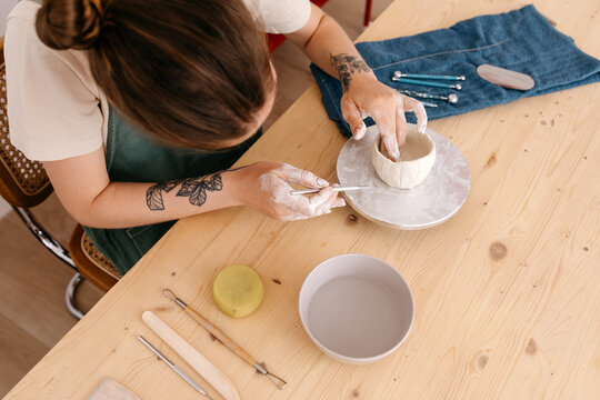 Crop artisan designing clay bowl