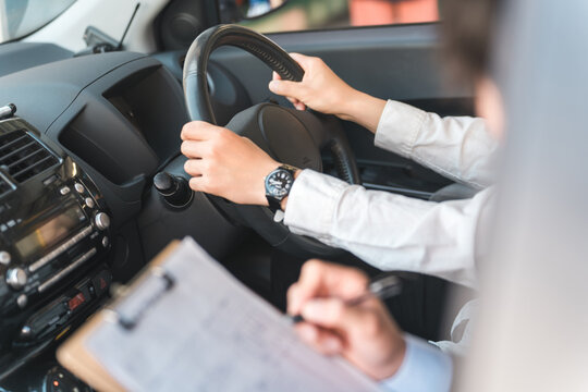 教習所で指導する教官と運転免許を取得するため受講する中年の男性ドライバー