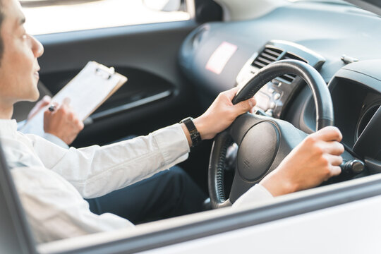 教習所で指導する教官と運転免許を取得するため受講する中年の男性ドライバー