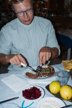 A man eating octopus in the taverna
