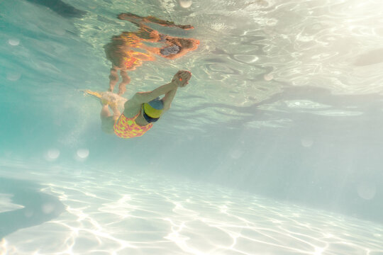 Woman swims underwater during her training in pool