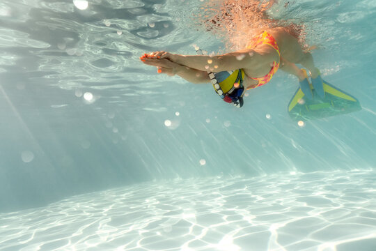 Woman swims underwater during her training in pool