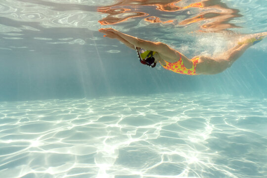 Woman swims underwater during her training in pool