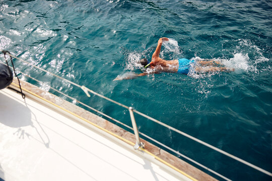 Man swims next to a boat