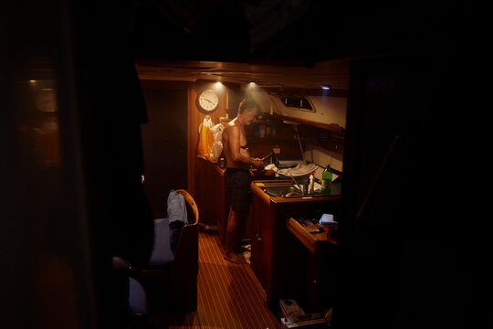 Man prepares dinner in the boat's lower deck