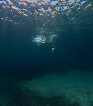 Divers swims towards the bottom of the sea