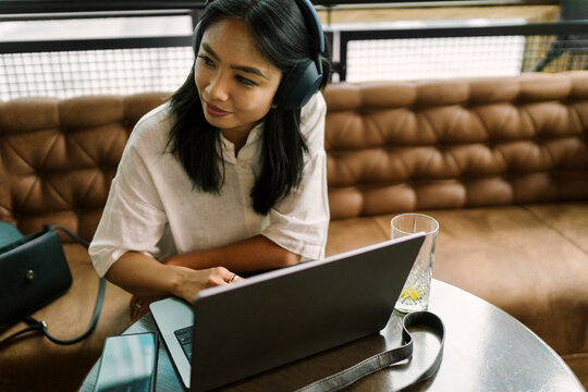 Woman Using Laptop in Cafe