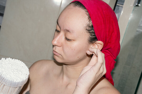 Woman Cleaning Ears with Cotton Swabs 