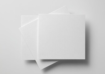 Three overlapping square blank white paper sheets on a light grey, minimal background