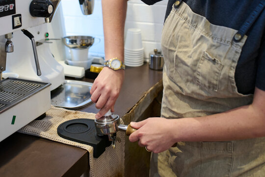 Barista Preparing Espresso at Coffee Shop in Morning Light